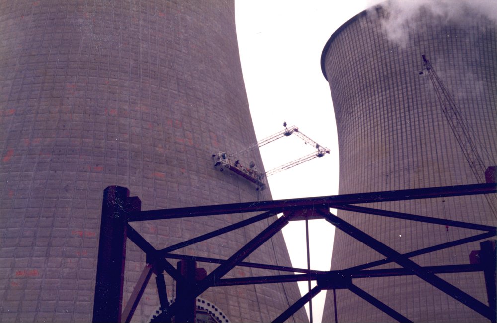 Specialist crew on a suspended platform cleaning a cooling tower